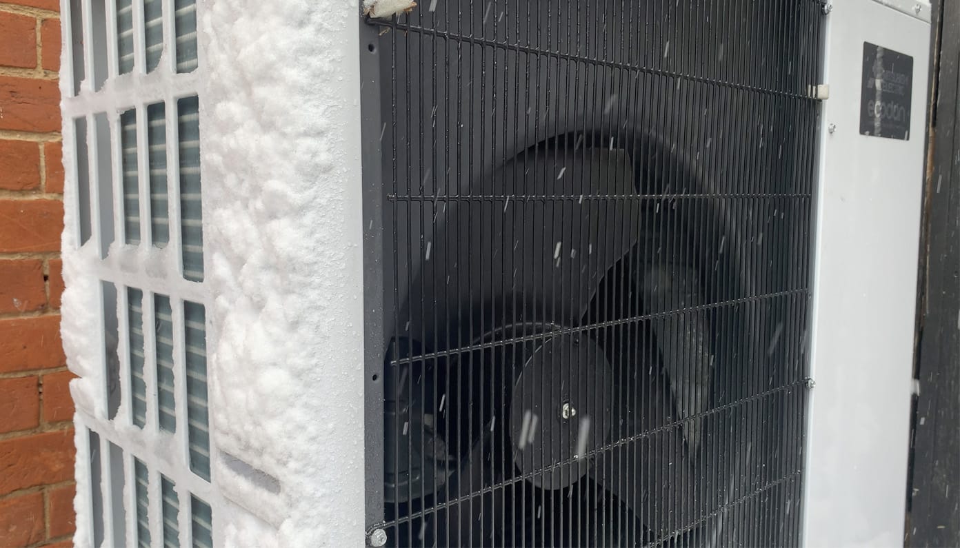 Cold-climate heat pump outdoor unit operating in snow